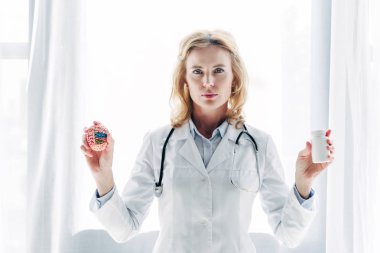 Beyaz önlüklü doktor klinikte beyin ve ilaç dolu şişe örneği taşıyor. 