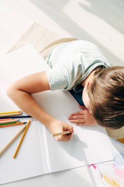 Kalemle çizim yapan disleksisi olan çocuğun üst görünümü 