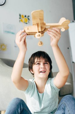 cute kid with dyslexia playing with wooden plane  clipart