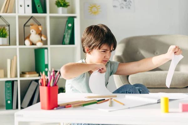 Niño Irritado Con Dislexia Perforando Papel Sentado Mesa — Foto de Stock