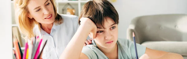 Plano Panorámico Niño Triste Con Dislexia Sosteniendo Lápiz Sonriente Psicólogo — Foto de Stock