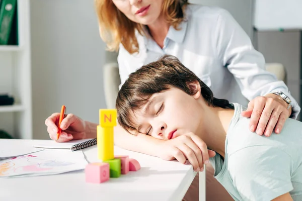 Cropped View Child Psychologist Hugging Kid Dyslexia Sleeping Table — Stock Photo, Image