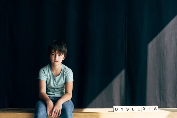 Kind Mit Legasthenie Blickt Kamera Und Sitzt Neben Holzwürfeln Mit — Stockfoto