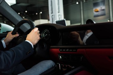 Kyiv, Ukrayna - 7 Ekim 2019: modern porshe 'de direksiyon tutan adamın kırpılmış görüntüsü