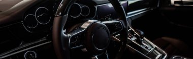 KYIV, UKRAINE - OCTOBER 7, 2019: panoramic shot of steering wheel near changing gear in porshe clipart