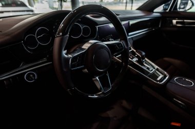 KYIV, UKRAINE - OCTOBER 7, 2019: selective focus of steering wheel near changing gear in porshe clipart