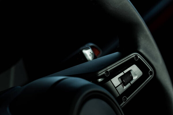 KYIV, UKRAINE - OCTOBER 7, 2019: close up of buttons on steering wheel in modern porshe
