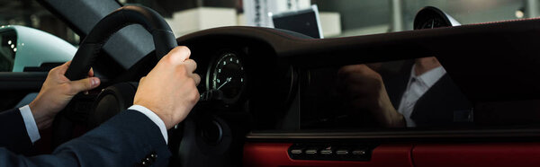 КИЕВ, УКРАИНА - 7 ОКТЯБРЯ 2019: панорамный снимок человека, держащего руль в современном порше
