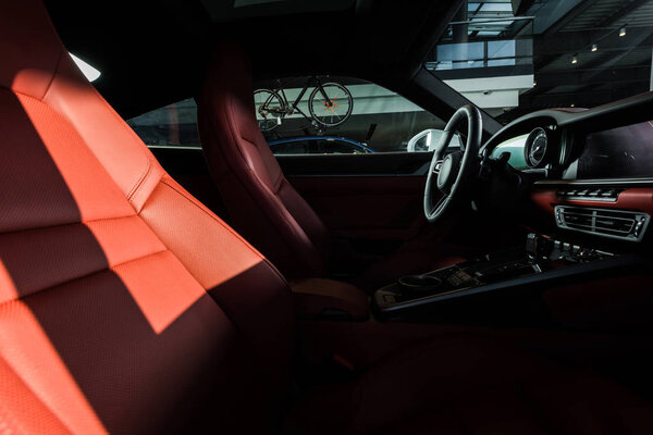 КИЕВ, УКРАИНА - 7 ОКТЯБРЯ 2019 г.: солнце на красных автомобильных сидениях возле руля в порше

