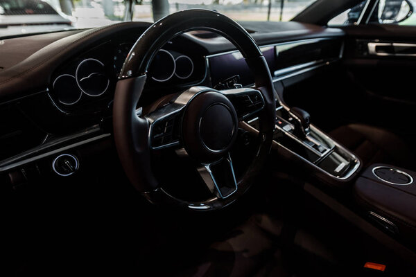 KYIV, UKRAINE - OCTOBER 7, 2019: selective focus of steering wheel near changing gear in porshe