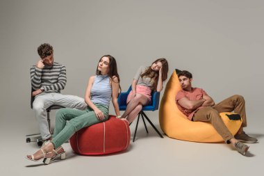 bored friends sitting on different chairs, on grey clipart