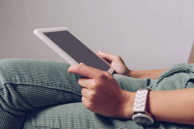 Gri üzerinde izole edilmiş, kopyalama alanı olan dijital tablet kullanan bir kadın görüntüsü