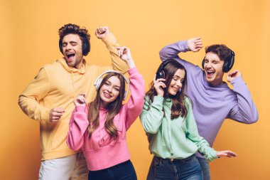 duygusal arkadaşlar kulaklıkla müzik dinliyorlar ve birlikte dans ediyorlar, sarıda soyutlanmışlar.