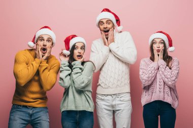 Süveter ve Noel Baba şapkalı, pembe izole arkadaşlar.