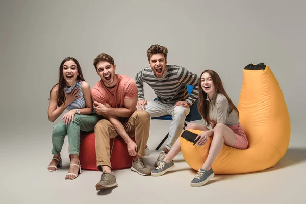 Emotional Friends Laughing Sitting Different Chairs Grey — Stock Photo, Image