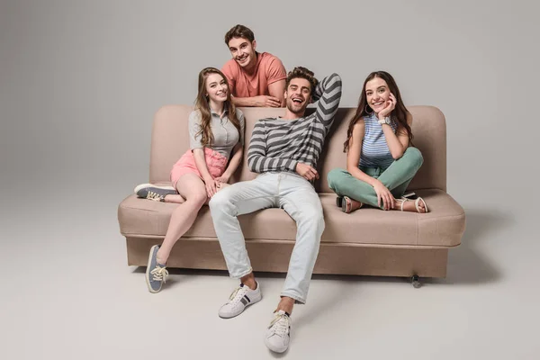 Smiling Young Friends Sitting Sofa Grey — Stock Photo, Image