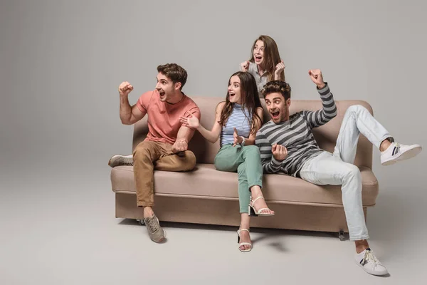 Excited Young Friends Cheering Sitting Sofa Grey — Stock Photo, Image