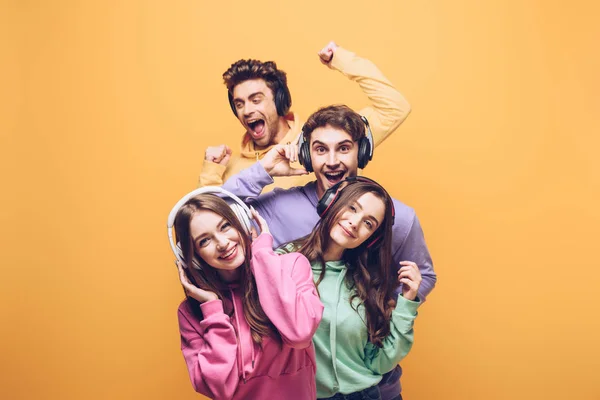 Amigos Alegres Escuchando Música Auriculares Bailando Juntos Aislados Amarillo — Foto de Stock