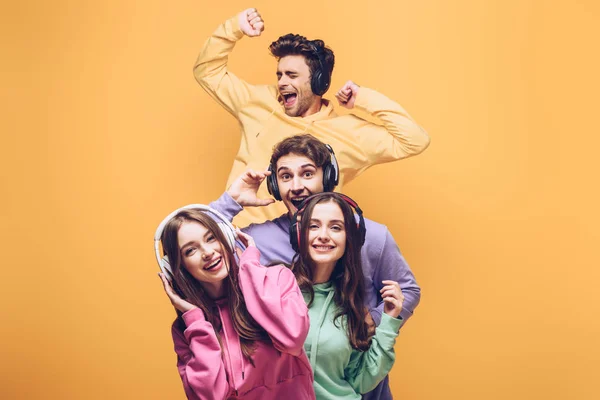 Amigos Emocionais Ouvindo Música Fones Ouvido Dançando Juntos Isolados Amarelo — Fotografia de Stock