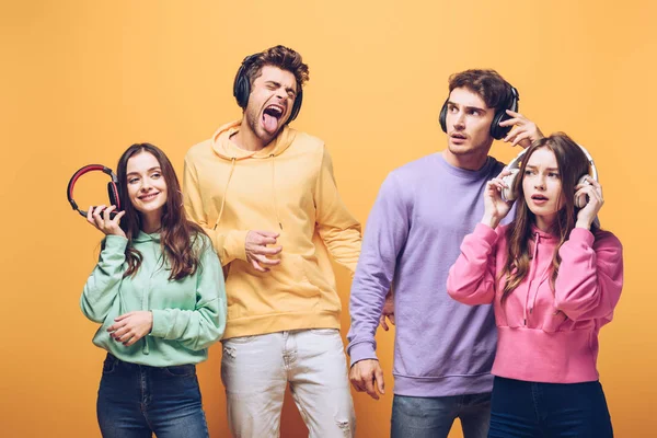 Amigos Emocionales Escuchando Música Auriculares Bailando Juntos Aislados Amarillo — Foto de Stock