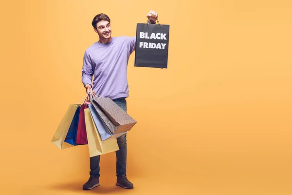 Sonriente Hombre Sosteniendo Bolsas Compras Viernes Negro Amarillo —  Fotos de Stock