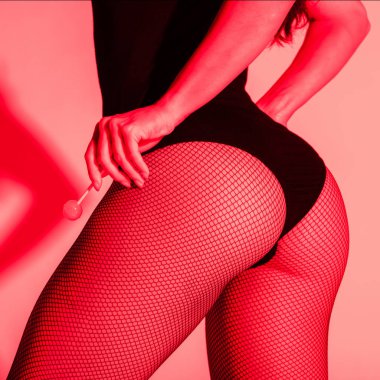 Kırmızı ışıkta lolipop tutan balıkçı taytlı seksi kalçalı bir kız.