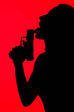 Kırmızıda izole edilmiş silah yalayan cezbedici kadının silueti.
