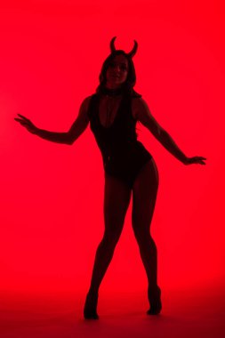 silhouette of attractive sexy woman in Devil costume, isolated on red clipart
