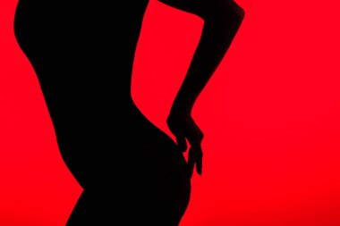 black silhouette of beautiful buttocks of seductive girl, isolated on red clipart