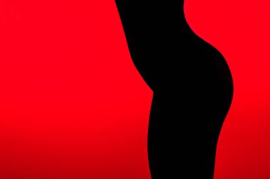 Kırmızıda izole edilmiş, seksi kalçalı siyah bir kadın.