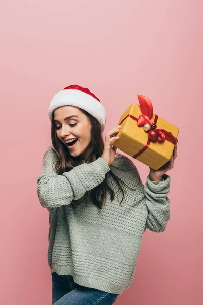 Excited Woman Sweater Santa Hat Holding Christmas Gift Isolated Pink — Stock Photo, Image
