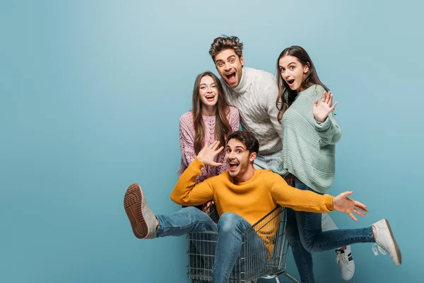 Amigos Riendo Divertirse Con Carrito Compras Aislado Azul — Foto de Stock