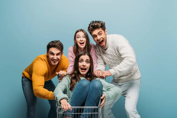 Bange Vrienden Schreeuwen Hebben Plezier Met Winkelwagentje Geïsoleerd Blauw — Stockfoto