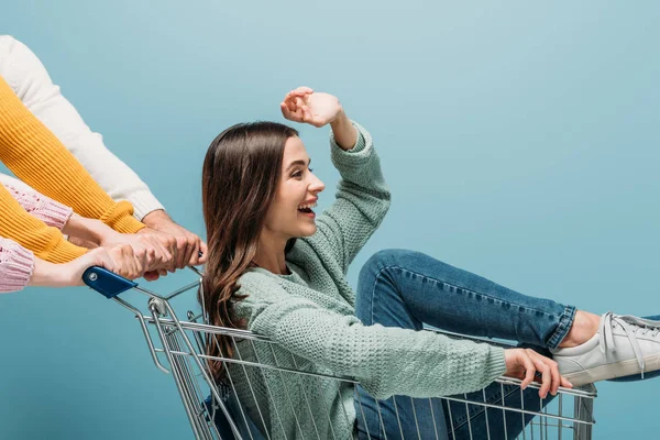 Friends Riding Laughing Girl Shopping Cart Isolated Blue — Stock Photo, Image