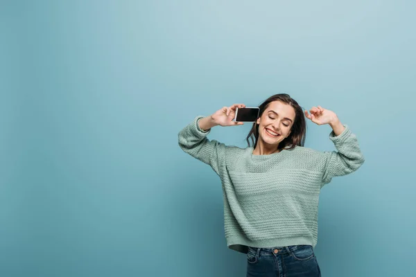 Glimlachende Vrouw Praten Smartphone Met Leeg Scherm Geïsoleerd Blauw — Stockfoto