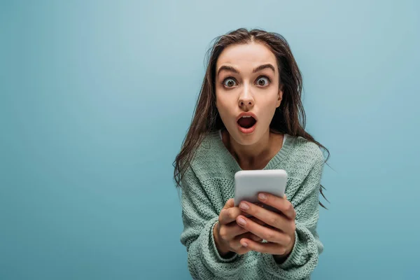 Mulher Chocada Com Boca Aberta Usando Smartphone Isolado Azul — Fotografia de Stock