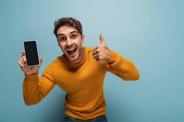 Excited Man Showing Thumb Smartphone Blank Screen Isolated Blue — Stock Photo, Image