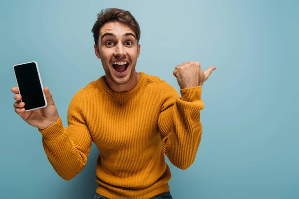 Excited Man Gesturing Showing Smartphone Blank Screen Isolated Blue — Stock Photo, Image