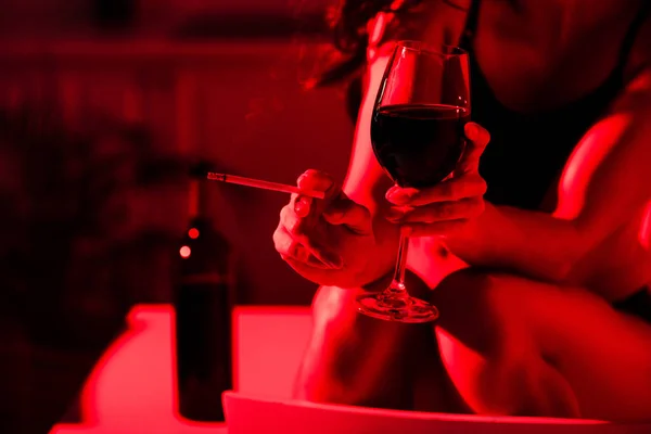 Обрезанный Вид Сексуальной Девушки Сигаретой Бокалом Вина Красном Свете — стоковое фото
