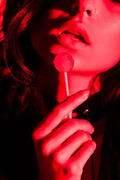 Vista Recortada Mujer Apasionada Atractiva Comer Piruleta Luz Roja — Foto de Stock