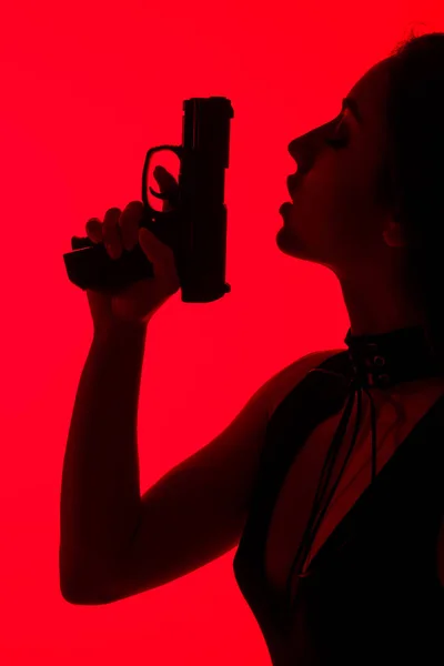 Silhueta Mulher Criminosa Sedutora Segurando Arma Isolada Vermelho — Fotografia de Stock