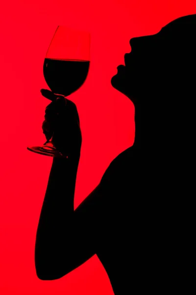 Silhouet Van Aantrekkelijke Sexy Vrouw Met Glas Wijn Geïsoleerd Rood — Stockfoto
