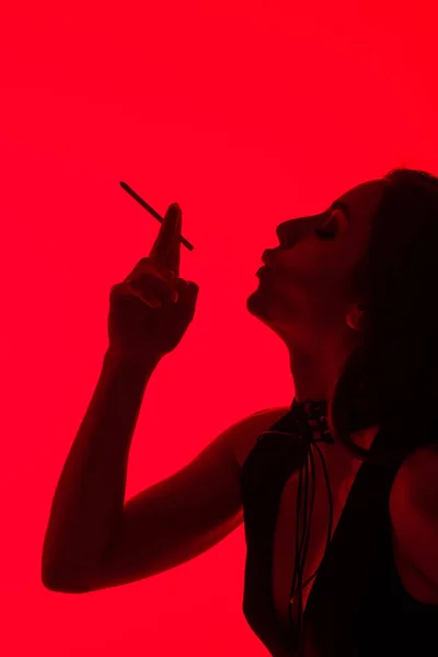 Silhouet Van Aantrekkelijke Sexy Meisje Roken Sigaret Geïsoleerd Rood — Stockfoto