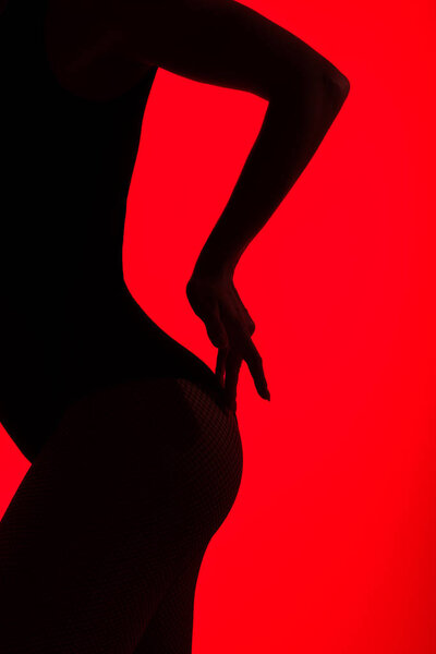 black silhouette of sexy buttocks of passionate woman, isolated on red