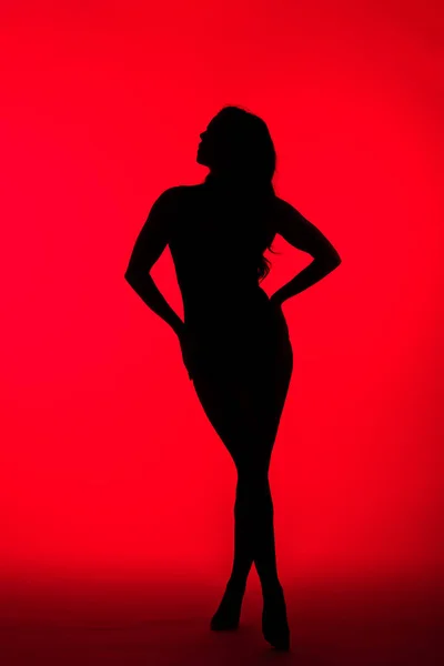 红色上迷人女人的黑色轮廓 — 图库照片