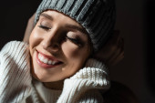 portrét krásné usmívající se dívky ve svetru a klobouku