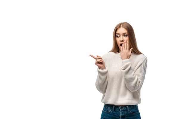 白いセーターを着たショックを受けた若い女性が口を指差して覆い — ストック写真