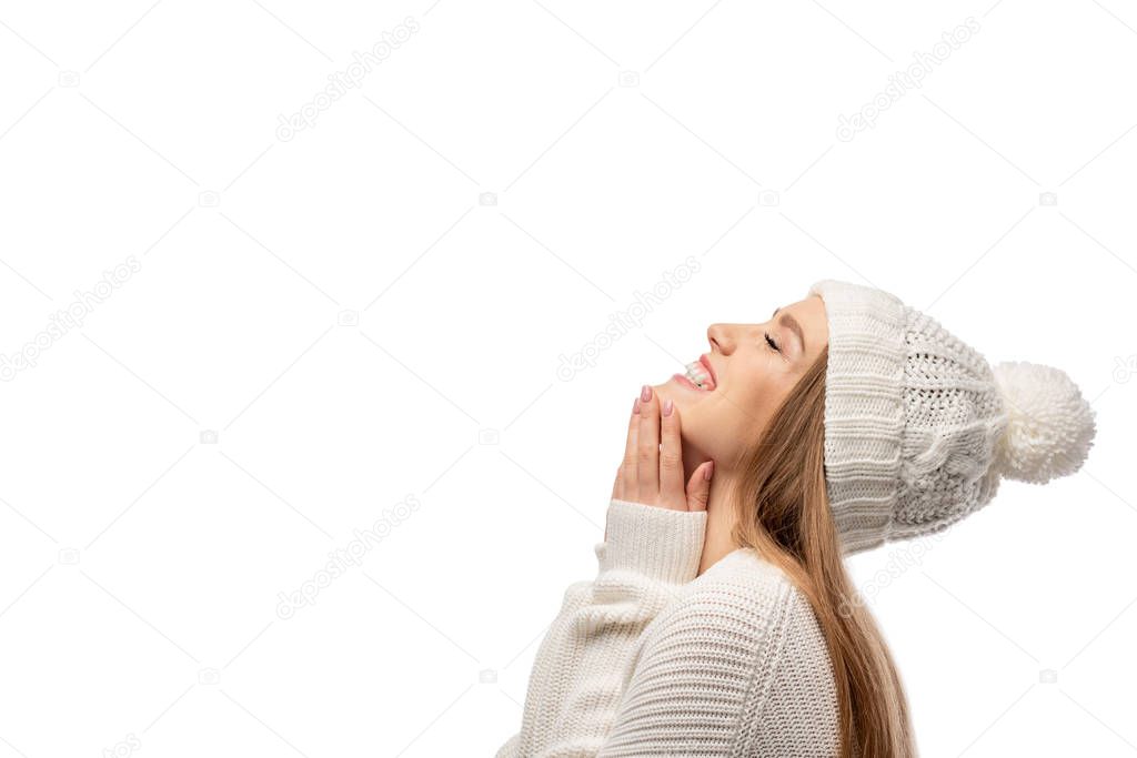 attractive cheerful woman posing in white knitted sweater and hat, isolated on white