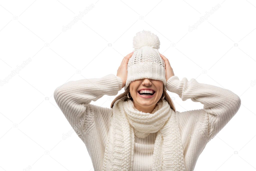 attractive laughing woman warming up in white knitted hat, isolated on white