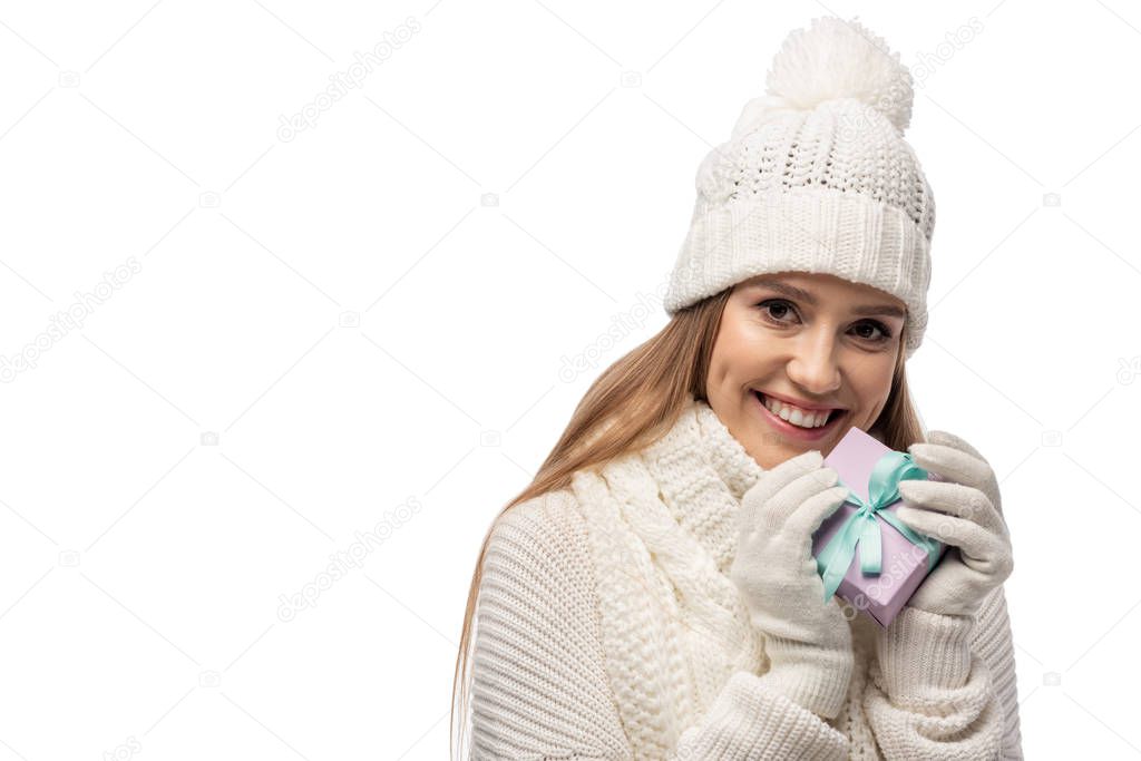happy woman in scarf, gloves and hat holding gift box, isolated on white